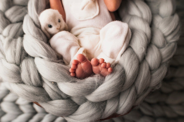 Baby with yarn blanket